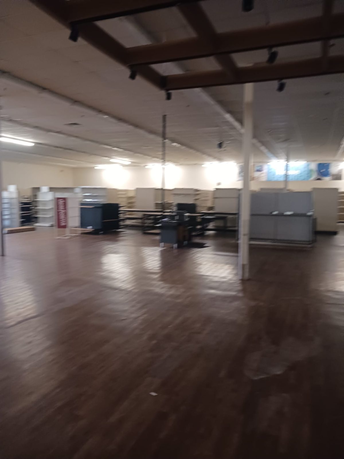 Glued-down wood-look flooring in a store before removal