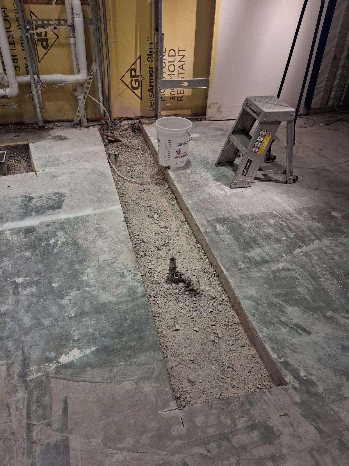 Saw-cut trench opened through a concrete slab