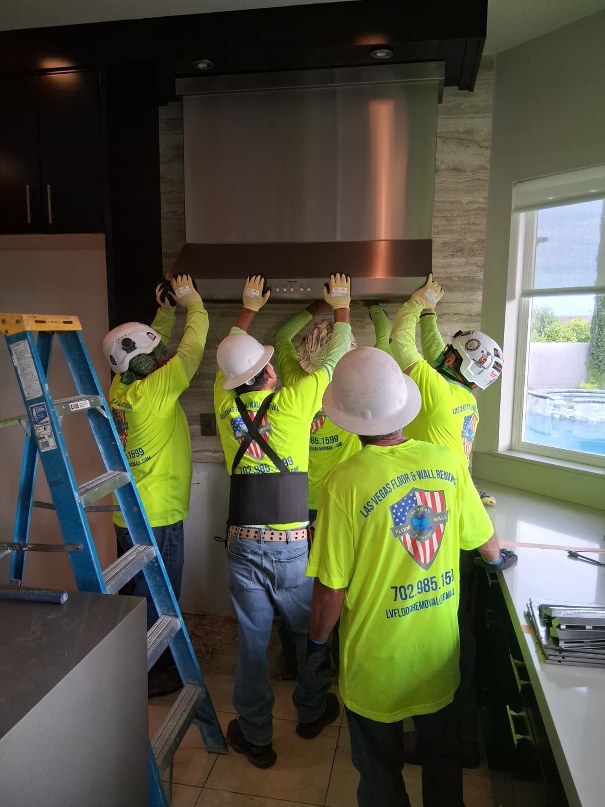 Las Vegas Floor & Wall Removal crew removing a range hood on a job